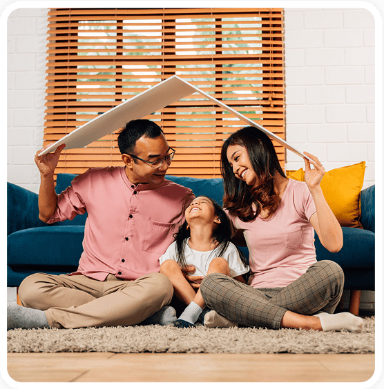 Family sitting together under a cardboard roof.