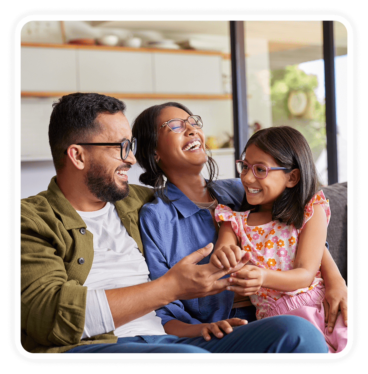 Family laughing together on a cozy sofa.